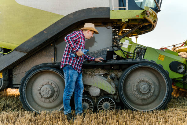 istock Farmer controlling harvest in his field, using laptop 1265259105