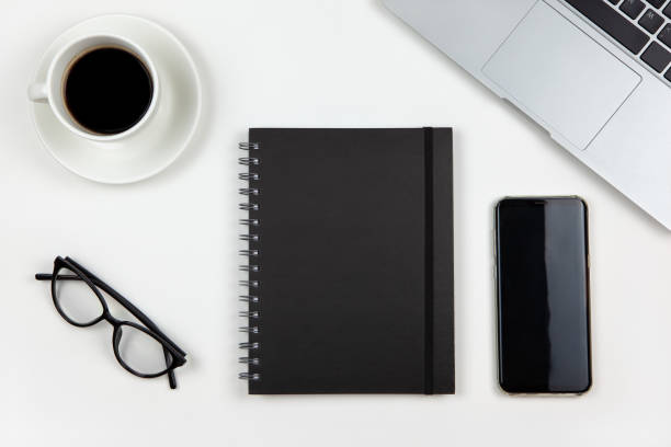 istock Modern working space, top view. Laptop, coffee, notepad, smart phone, glasses on white background, copy space, flat lay. Desktop of freelancer. Work from home, using technology concept 1265259107