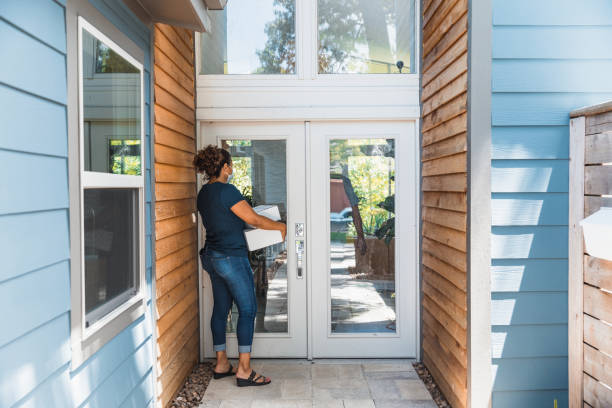 istock Delivery person standing at customer's front door 1265260474