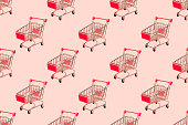 Shopping cart seamless pattern on pastel pink background.