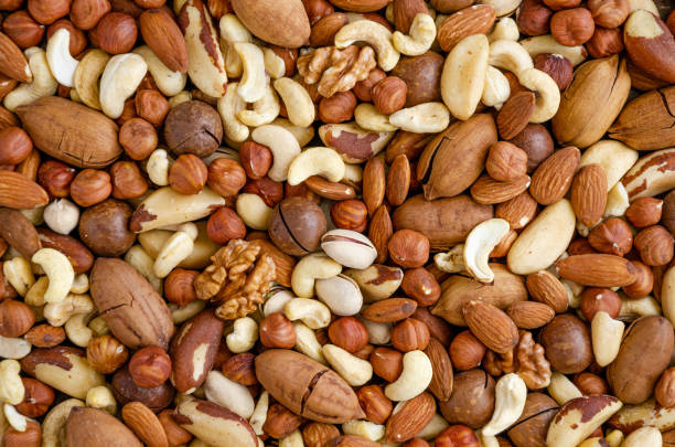 istock Almonds, hazelnuts, cashews, Brazilian nuts, walnut, macadamia, pecans and pistachios mixed together. Natural background. Healthy food. Top view. 1265266788