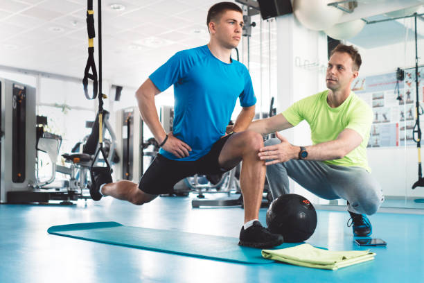 istock Personal trainer assisting his client, working with suspension straps 1265268457