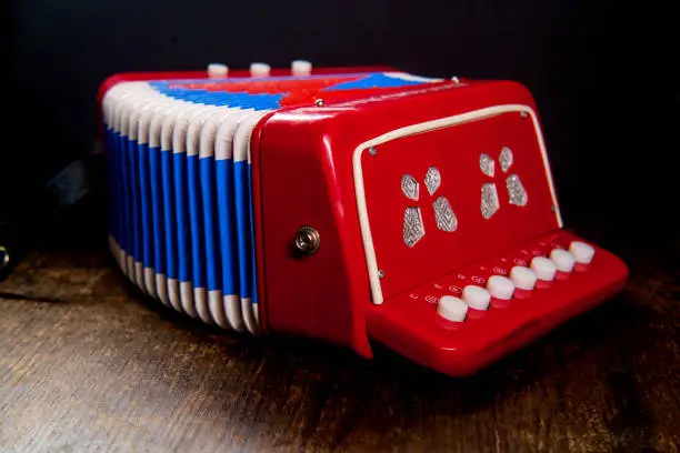 Vintage kids toy musical instrument accordian with dark moody lighting