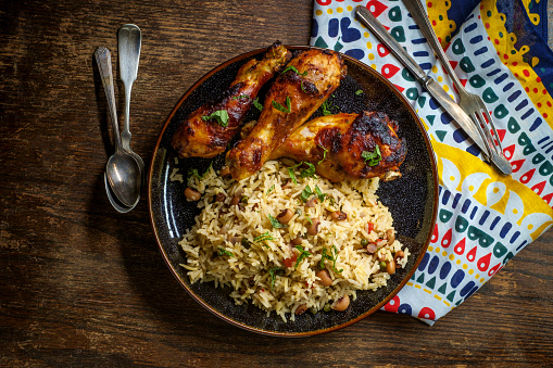 African cuisine grilled chicken legs with jollof rice with orzo and black eyed peas