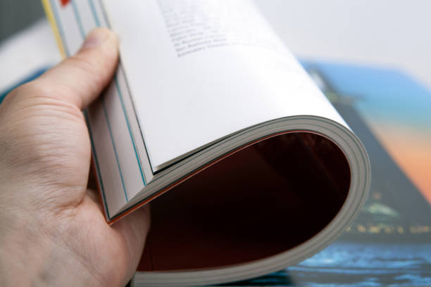 istock glossy magazines in the human hand paging closeup 1265268993