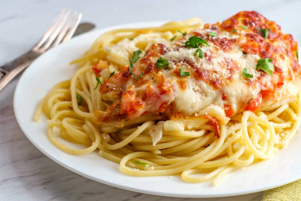 Italian Bruschetta Chicken Spaghetti Italian baked bruschetta chicken served over spaghetti noodles parmesan stock pictures, royalty-free photos & images