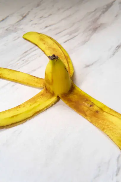 Slippery comedy banana peel on marble floor as hazard to slipping and falling