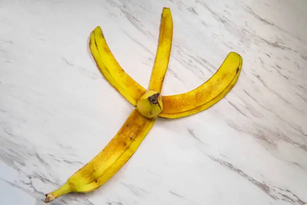 Slippery comedy banana peel on marble floor as hazard to slipping and falling