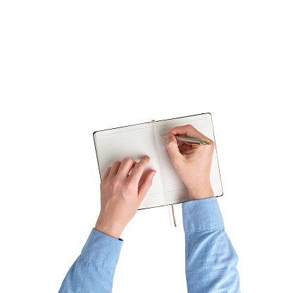 Male hands in a shirt are taking notes in a diary. top view and white background. Isolated