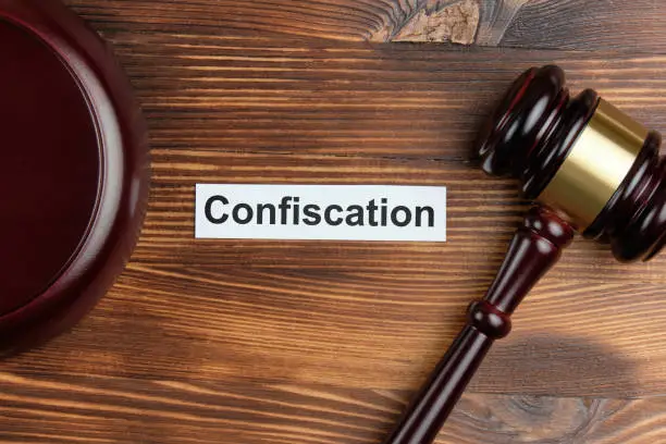 Photo of The word confiscation on a white sticker next to the judge hammer