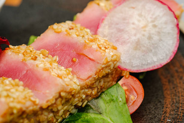 istock Tuna in sesame seeds with sauce on a white plate. 1265278093