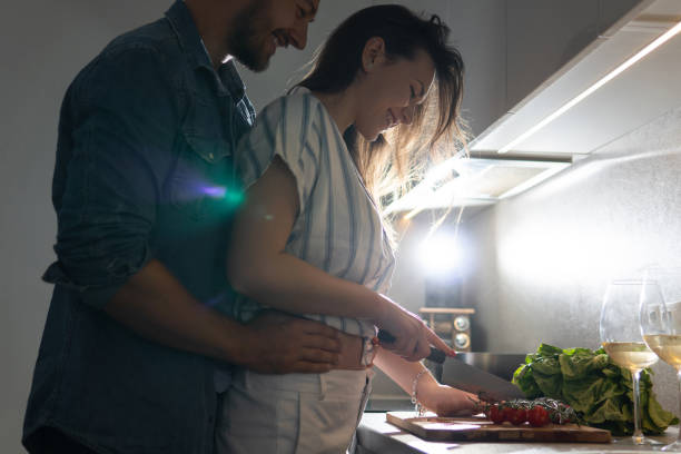 istock Young couple cooking tasty dinner together in a kitchen 1265280321