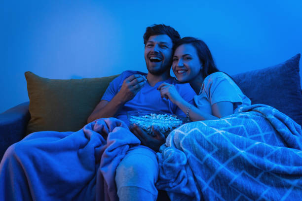 istock Young and happy couple watching comedy TV show 1265280667