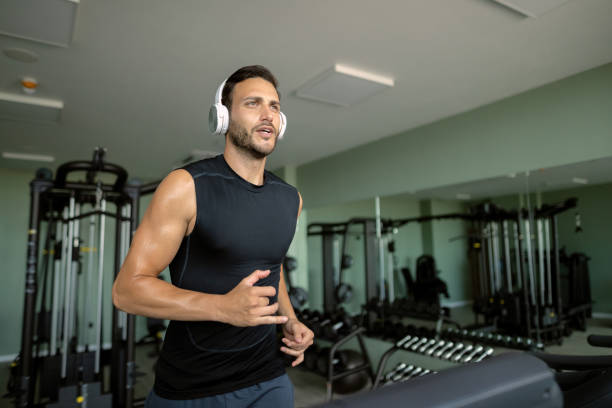 istock Athletic man jogging on running track while working out in a gym. 1265280759
