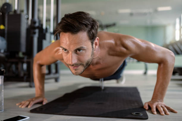 istock Young athletic man doing push-ups during sports training in a gym. 1265283274