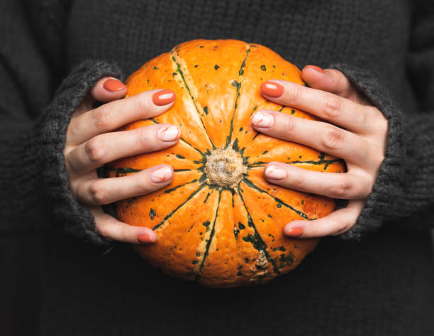 la donna con un maglione a maglia grigia tiene una zucca. - women mature adult beauty beauty in nature foto e immagini stock