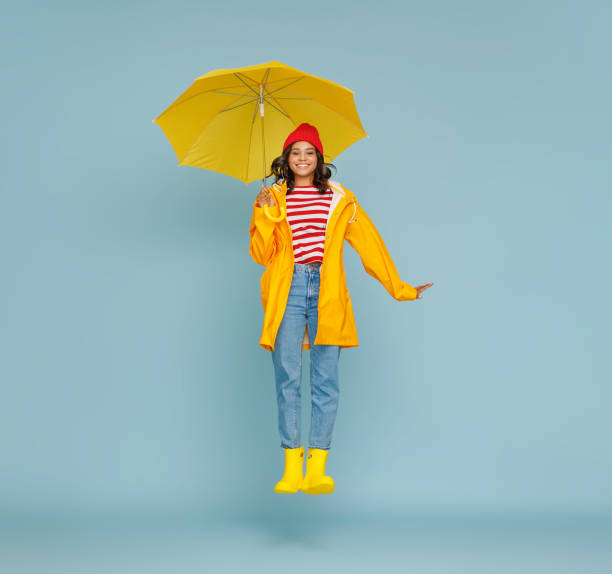 istock Excited ethnic female leaping with umbrella 1265284691