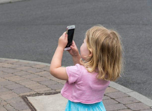 istock Little girl takes a photo with a smartphone 1265287708