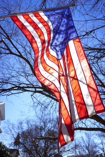 The sun shines through an American flag in Auburn, Ala.