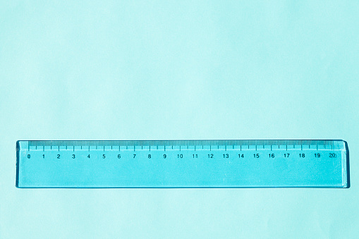 Blue plastic ruler isolated on blue background