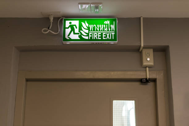 istock Green emergency exit sign showing the way to escape.Fire exit in the building. 1265299972