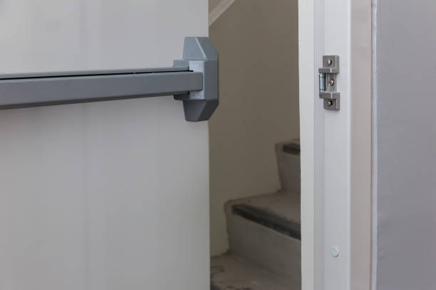istock Emergency fire exit door. Closed up latch and rusty door handle of emergency exit. Push bar and rail for panic exit. Open one way door.  steel of handle for the white door fire exit 1265300001