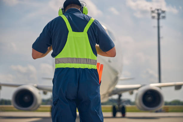 istock Airport worker in uniform meeting a plane 1265300213