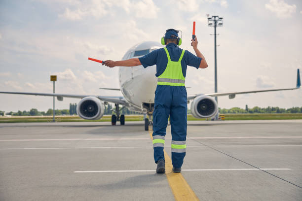 istock Man signaling the pilot with marshalling wands 1265300218