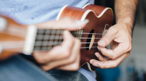istock A young man playing the ukulele, Concept music player 1265301571
