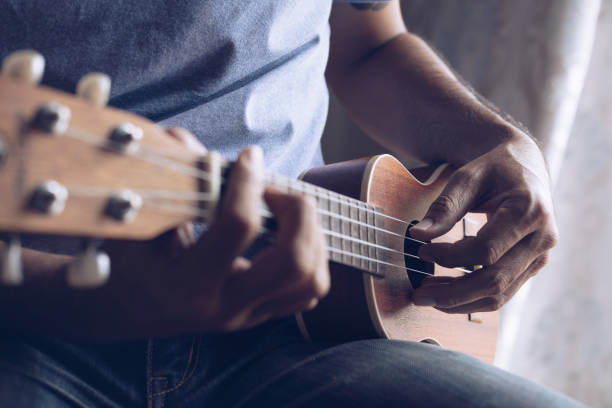 istock A young man playing the ukulele, Concept music player 1265301575
