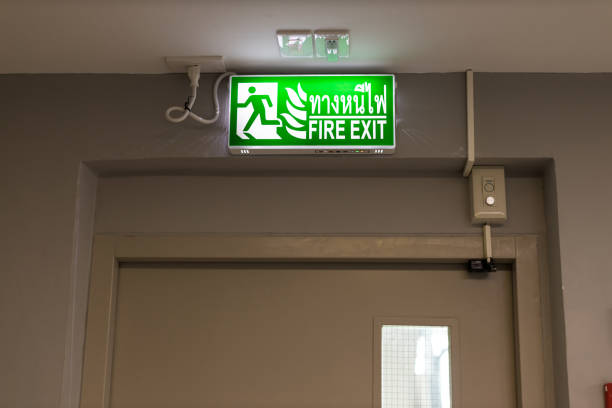 istock Green emergency exit sign showing the way to escape.Fire exit in the building. 1265305211