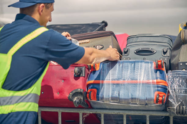istock Airport worker putting customer baggage on trolleys 1265305342