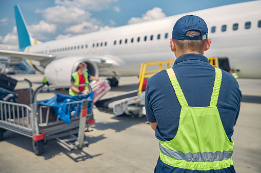 Manejadores de equipaje cargando maletas en un avión photo