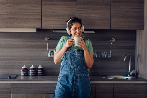 Portrait of a beautiful girl enjoying coffee and music in the morning.
