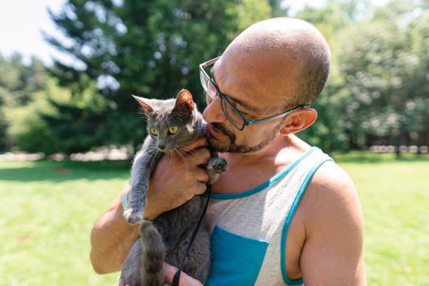 istock Man taking his cat in the park 1265308612