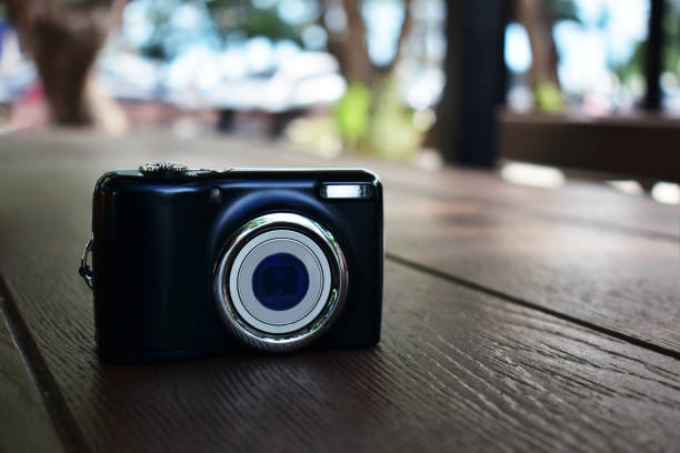 istock Compact digital camera Black in hand and photo. 1265312323