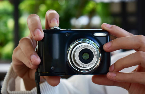 istock Compact digital camera Black in hand and photo. 1265314696