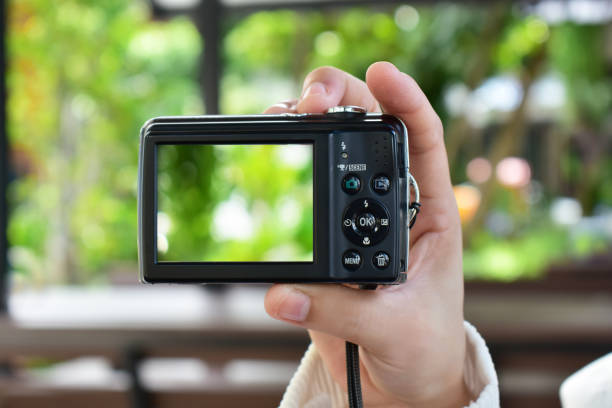istock Compact digital camera Black in hand and photo. 1265314862