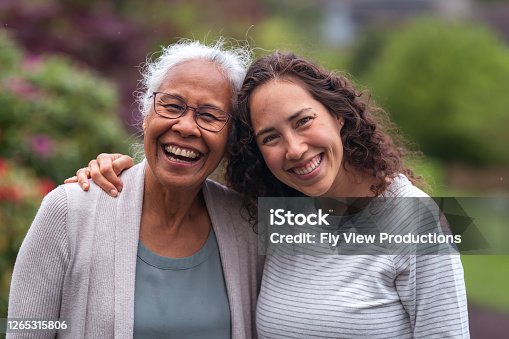istock Mixed race mother and daughter walk and talk together outside 1265315806