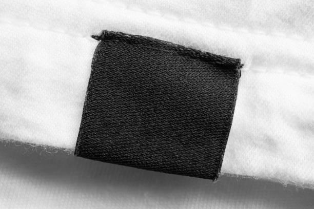 черный пустой прачечная одежды этикетки на белом фоне хлопчатобумажной рубашке - label textile shirt stitch стоковые фото и изображения