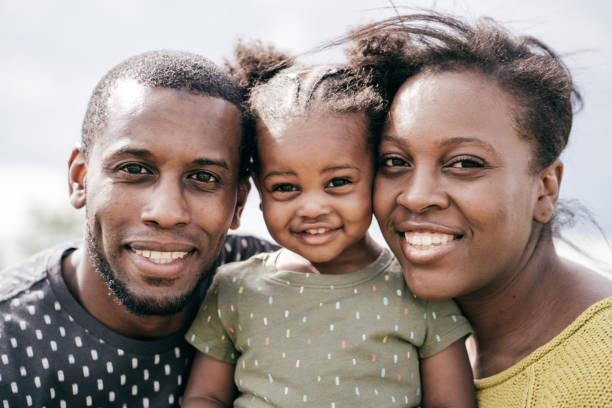 close up family portrait- two young parents and adorable baby girl - babies and children close up horizontal looking at camera imagens e fotografias de stock