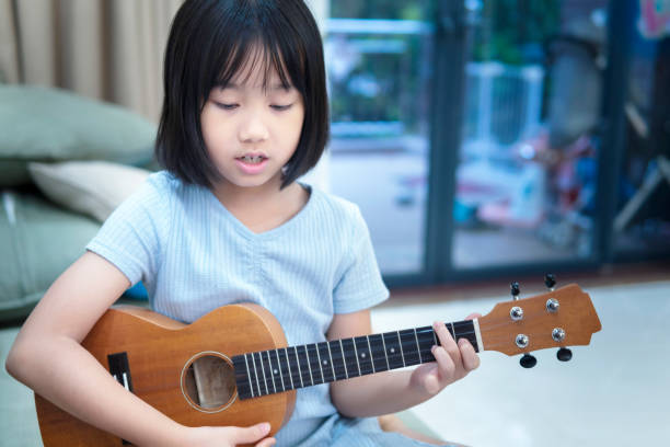 istock A little girl practicing ukulele at home 1265348057