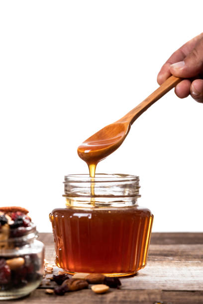 istock Honey dripping into a glass jar. 1265365838