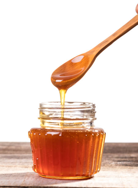 istock Honey dripping into a glass jar. 1265365848