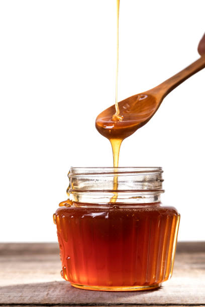 istock Honey dripping into a glass jar. 1265365857