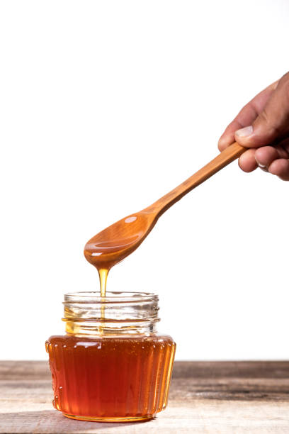 istock Honey dripping into a glass jar. 1265365868
