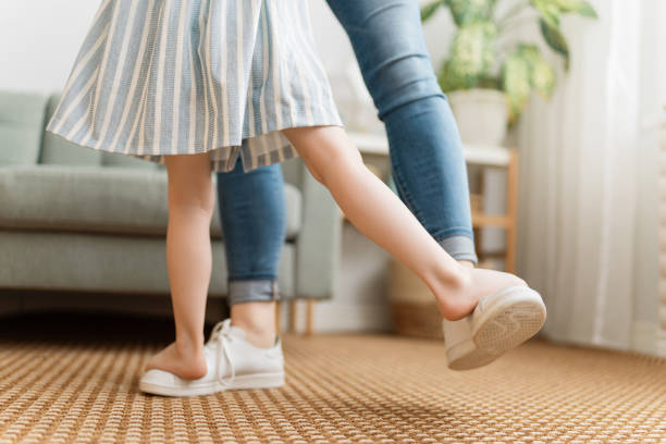 Mom and her daughter are dancing.