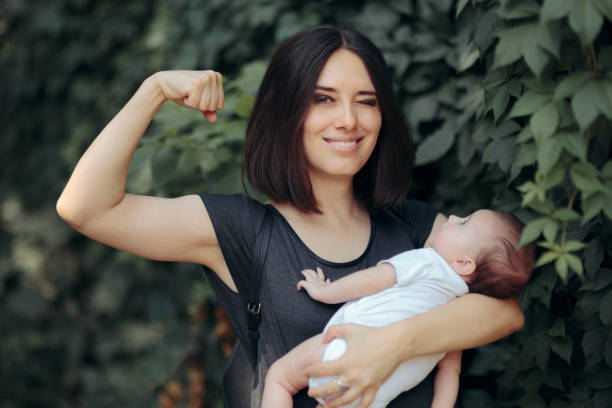 super mamá en fuerte pose poderosa sosteniendo recién nacido - mother superior fotografías e imágenes de stock