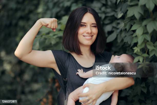 Super Mom In Strong Powerful Pose Holding Newborn Stock Photo - Download Image Now - Mother, Strength, Authority
