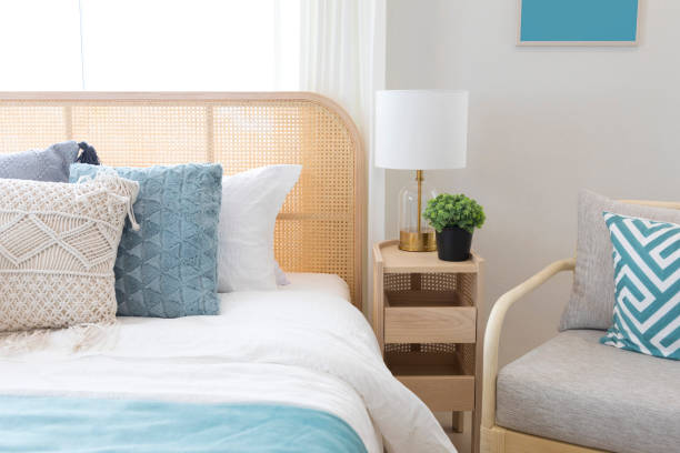 istock Elegant bedroom interior with lamps over bedside tables, comfortable bed, blue pillow and blanket. 1265374455